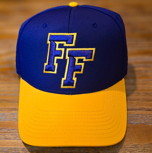 Purple cap with a yellow bill, yellow button, purple eyelets with embroidered FF logo in Purple outlined in yellow.  Cap is sitting on a wooden surface