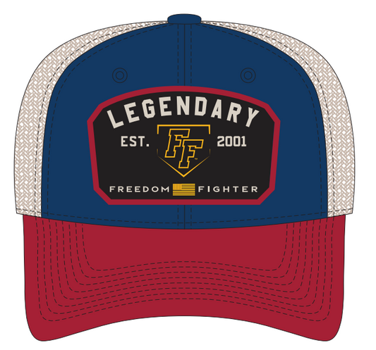 Trucker cap with blue front panel with blue button and eyelets, a red bill, and stone colored back panel.  Front panel with 'Legendary Freedom Fighter' black patch outlined in red and embroidered with "LEGENDARY Est. 2001" in gray,  a yellow "FF" Logo outlined with the shape of a yellow baseball home plate and the words "FREEDOM FIGHTERS" along the bottom in gray with a yellow flag between the words.