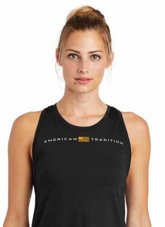 A woman wearing a black sleeveless tank top with 'AMERICAN TRADITION' printed in white across the chest, separated by a small gold American flag graphic.